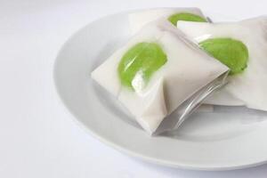 Kue Bugis, Indonesian jajan pasar, traditional snack of glutinous rice flour cake filled with sweet grated coconut, underlined with banana leaf. Popular snack during Ramadan as Takjil photo