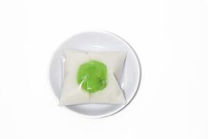 Kue Bugis, Indonesian jajan pasar, traditional snack of glutinous rice flour cake filled with sweet grated coconut, underlined with banana leaf. Popular snack during Ramadan as Takjil photo