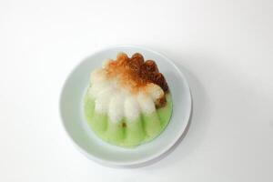 Green putu ayu is an Indonesian local cake made from rice flour and coconut milk with glaze of coconut photo