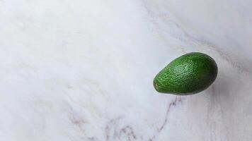 avocado jumping Aan een marmeren keuken tafel, kopiëren ruimte voor uw tekst, stop motion animatie 4k vlak leggen video