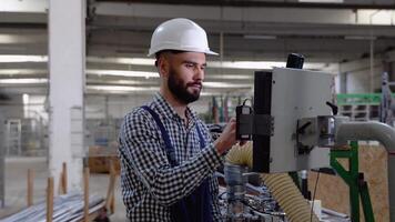 operatör av maskin. industriell arbetstagare bär säkerhet enhetlig och hjälm inomhus i fabrik video