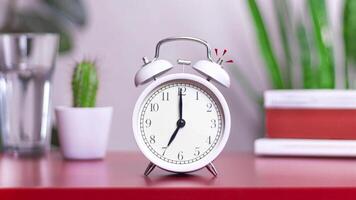 Alarm clock is ringing at 7 am. Looped stopmotion animation footage white Old fashioned alarm clock ringing on the hour, clock staggers from side to side and rings drawn motion elements 4k video