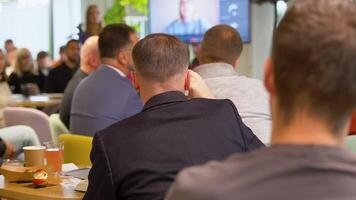 alto falante dando uma conversa dentro conferência em ligar às o negócio evento. o negócio e empreendedorismo conceito. foco em irreconhecível pessoas dentro público. público às a conferência corredor video