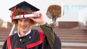 Funny red -haired graduate corrects the hairstyle with a diploma video