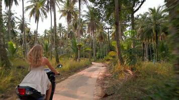 Caucasian woman riding a scooter on a tropical island in Thailand. video