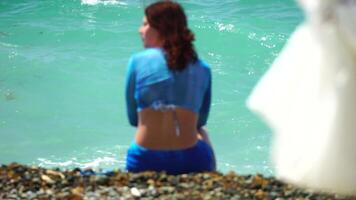 donna andando nel mare su spiaggia a tramonto durante estate vacanza vacanze rallentatore, avvicinamento, indietro Visualizza. peso perdita e corpo Immagine concetto. irriconoscibile donna con Perfetto in forma corpo gode mare spiaggia video