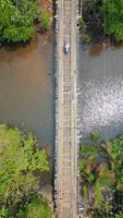 topp se av en skoter ridning på en trä- bro tvärs över de flod. video