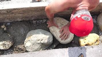 Construction, Worker Hands smooth wet cement in wooden frame at a construction site during daytime to ensure an even surface video