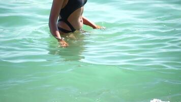 femme Aller dans mer sur plage à le coucher du soleil pendant été vacances vacances au ralenti, fermer, retour voir. poids perte et corps image concept. méconnaissable femme avec parfait en forme corps jouit mer plage video