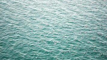 Meer Wasser Oberfläche. Antenne Aussicht auf klar azurblau Meer Wasser. Sonne Blendung. abstrakt nautisch Sommer- Ozean Natur. Urlaub, Ferien und Reise Konzept. niemand. schleppend Bewegung. Wetter und Klima Veränderung video