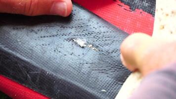 Patch repair kit with glue for inflatable boats, SUP, raft. Man repair inflatable sup on the beach. video