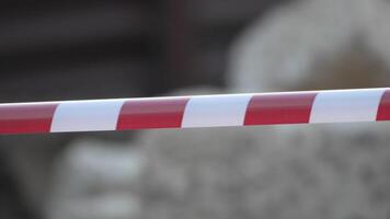 Red and white warning tape swinging in the wind. Protection sign. Don't cross the line. Red White caution tape pole fencing is protects for No entry. Backdrop without people, empty street. video