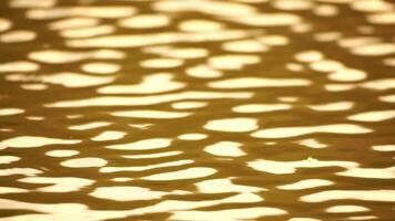 Sun reflecting on sparkling sea lake water surface, ocean at sunset, sunrise. Sunrays flickering in Ripples on water surface. Golden shimmering sea waves in sun. Slow motion. Abstract nautical nature video