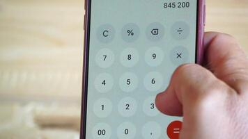 Mens, hand, smartphone, rekenmachine app, boekhouding. hand- van Mens houdt smartphone met rekenmachine app Open naar snel accuraat boekhouding, voor financieel record houden. video