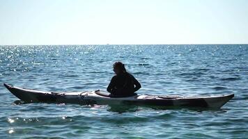 donna mare kayak. contento sorridente donna nel kayak su oceano, paddling con di legno remo. calma mare acqua e orizzonte nel sfondo. attivo stile di vita a mare. estate vacanza. video