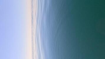 Vertical aerial view on sea water surface, camera flies over clear sea water. Sun glare. Abstract nautical summer ocean nature. Holiday, vacation and travel concept. Nobody. Weather and climate change video