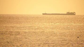 Cargo and dredging industrial ships sailing in to sea horizon. One large cargo ship grain carrier tanker in sea on sunny day. Transport, sea freight, sea transportation of cargo. Aerial view video