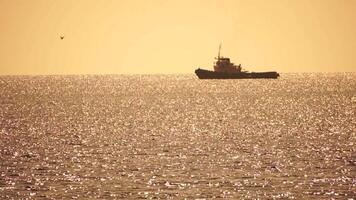 Tug boat in open calm sea, heading back to port at sunset, helps large container ships maneuver. Aerial view, maritime industry, oceanic transportation or business concepts. video