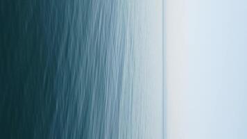 abstract antenne zee zomer oceaan zonsondergang natuur achtergrond. klein golven Aan water oppervlakte in beweging vervagen met gouden bokeh lichten van zon. vakantie, vakantie en recreatief concept. verticaal video