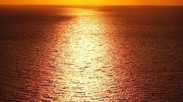 Meer Wasser Oberfläche. Antenne Aussicht auf golden Meer Wasser beim Sonnenuntergang. Sonne Blendung. abstrakt nautisch Sommer- Ozean Natur. Urlaub, Ferien und Reise Konzept. niemand. schleppend Bewegung. Wetter und Klima Veränderung video