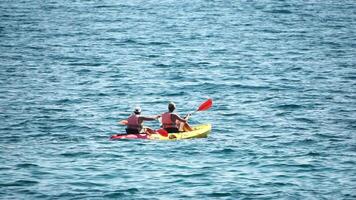 aérien vue de une famille kayak dans calme bleu mer. méconnaissable femme, homme et enfants. kayak sur turquoise mer l'eau pendant chaud journée à mer. été vacances vacances et Voyage concept video