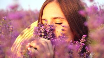 femme dans lavande champ - content Dame dans chapeau jouit ensoleillé jour, errant dans lavande champ, apprécier la nature. fille apprécie lavande bouquet fragrance, permanent dans champ, sur une clair journée. video