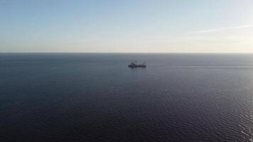 Cargo industrial ships sailing in to sea horizon. One large cargo ship grain carrier tanker in sea on sunny day. Transport, sea freight, sea transportation of cargo. Aerial view video