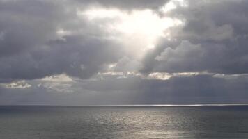 Aerial vertical view. Dramatic moody and gloomy rain clouds over sea. Abstract aerial nature summer ocean sunset sea and sky. Horizon. Vacation, travel and holiday concept. Weather and climate change video