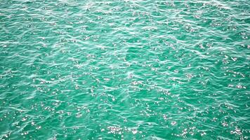 Sea water surface. Aerial view on clear azure sea water. Sun glare. Abstract nautical summer ocean nature. Holiday, vacation and travel concept. Nobody. Slow motion. Weather and climate change video