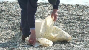 basura en playa - mayor hombre recoge basura en playa después tormenta, mantener limpieza y conservación ambiente. video