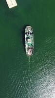 Ferry carrying cars and passengers across the sea, top down aerial drone view. Aerial vertical view on Ferry on the lake, transporting cars. deck of a boat carrying vehicles. video