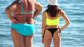 mujer yendo en mar en playa a puesta de sol durante verano vacaciones Días festivos camara lenta, de cerca, espalda vista. peso pérdida y cuerpo imagen concepto. contento mujer con Perfecto ajuste cuerpo disfruta mar playa video