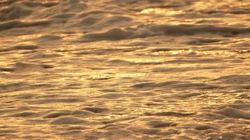 abstrakt verschwommen golden Meer beim Sonnenuntergang. Sonne spiegelt und funkelt auf Wellen mit Bokeh, leuchten warm Meer. Sommer- Ozean Natur Hintergrund. Urlaub, Ferien und Erholung. Wetter und Klima Veränderung video