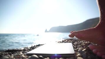 Man laptop sea. Working remotely on seashore. Happy successful man, male freelancer working on laptop by foot, relieves stress from work to restore life balance. Freelance, remote work on vacation video