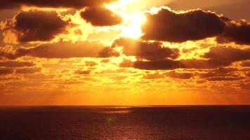 Timelapse dramatisk solnedgång med fluffig moln rör på sig i gyllene brinnande himmel över hav. abstrakt antenn natur sommar hav solnedgång hav och himmel bakgrund. semester, resa och Semester begrepp. antenn se video