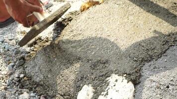 Construction, Worker Hands smooth wet cement in wooden frame at a construction site during daytime to ensure an even surface video