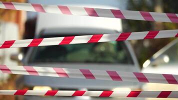 Red and white warning tape swinging in the wind. Protection sign. Don't cross the line. Red White caution tape pole fencing is protects for No entry. Backdrop without people, empty street. video