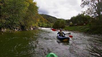 ein Kerl im ein Kajak Segel auf ein Berg Fluss. Wildwasser Kajak fahren, extrem Kajak fahren video