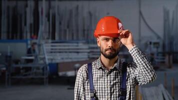 fabbrica lavoratore nel protettivo casco. uomo Lavorando su il produzione linea video