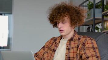 joven pelirrojo hombre utilizando ordenador portátil trabajando llamada conferencia con cliente en lugar de trabajo a co trabajando espacio video