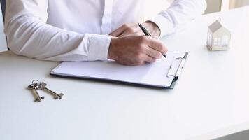 Male realtor signs a contract for the sale of an apartment video