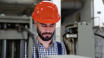 souriant industriel spécialiste permanent dans une métal construction fabrication. intelligent usine ouvrier en utilisant machine dans usine atelier. industrie et ingénierie concept video