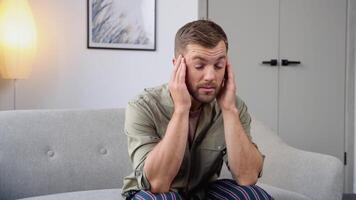 Man having a headache at home on sofa video