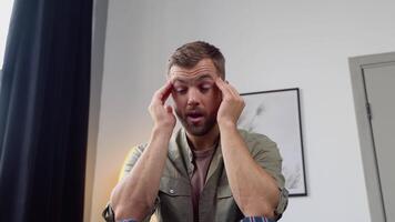 Mann haben ein Kopfschmerzen beim Zuhause auf Sofa video