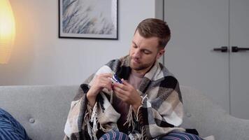 Jeune homme avec impulsion oxymètre sur main mesure oxygène saturation niveau à maison. oxymètre de pouls médical appareil, oxymétrie de pouls agrafe machine surveiller bœuf taux video