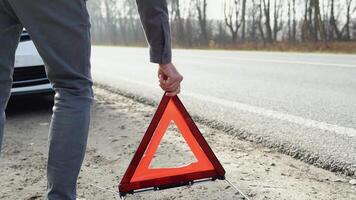 hombre poniendo triángulo precaución firmar en brumoso la carretera cerca roto coche video