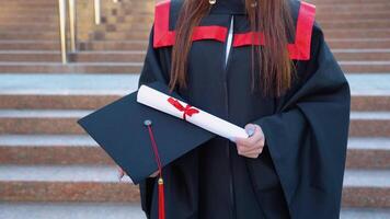 Master's hat and graduation diploma about higher education are in the female graduate's hands video