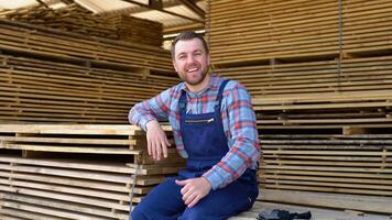 Young male worker in timber lumber warehouse. Concept - sale of lumber video