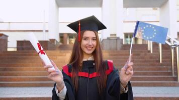 een meester afstuderen houdt een diploma van hoger onderwijs en EU vlag video