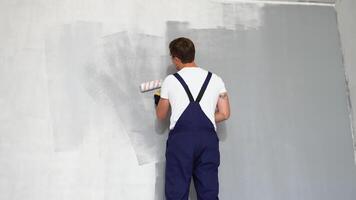 målare målning en hus vägg med en måla vält video